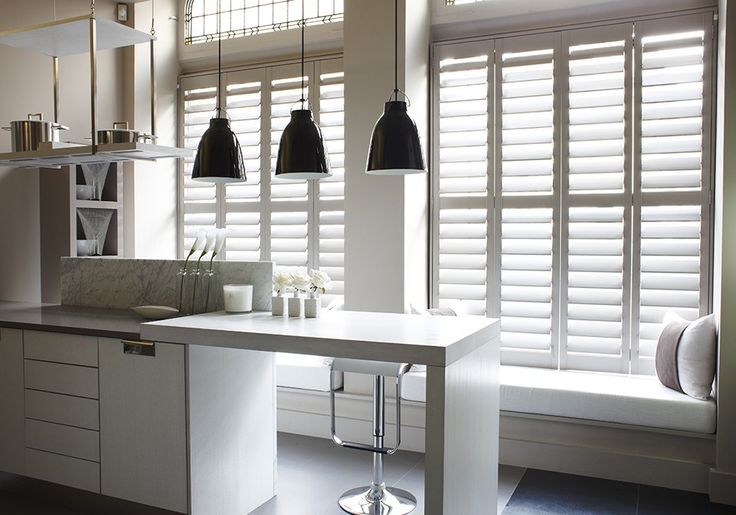 Tall plantation shutters fitted beside a kitchen seating area