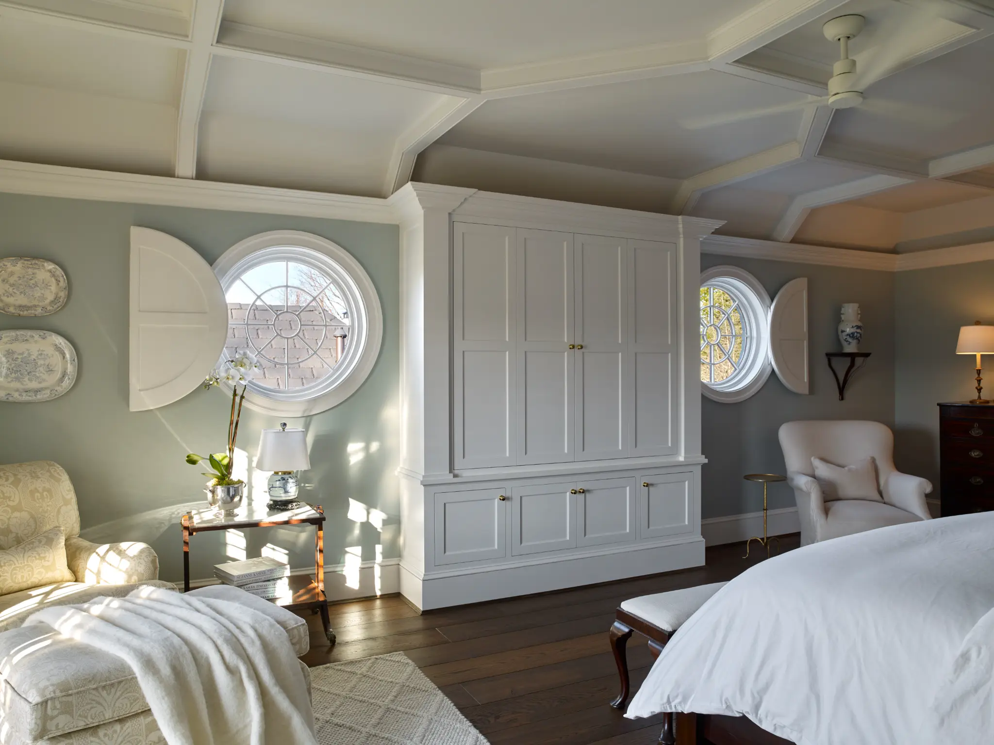 Oval window plantation shutters with warm interior lighting